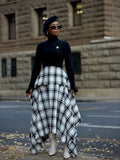 Black and white plaid asymmetric skirt with a peplum waist, worn with a black turtleneck