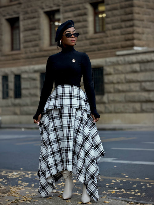 Black and white plaid asymmetric skirt with a peplum waist, worn with a black turtleneck