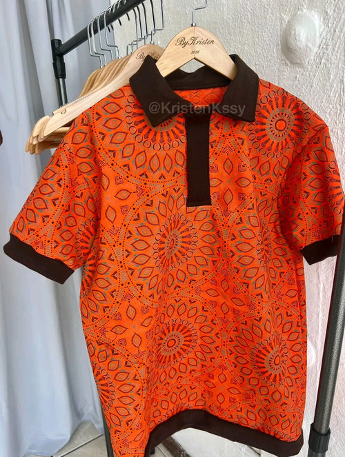 Shweshwe Golf Tshirt in Orange Safari Mandala print on a hanger