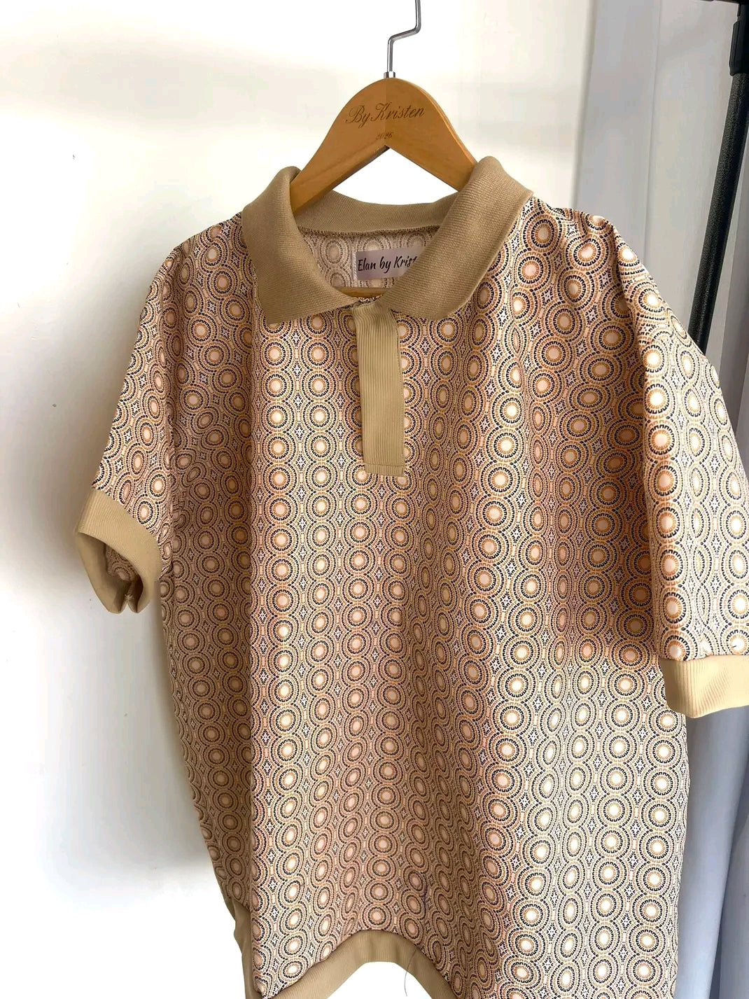 Shweshwe Golf Tshirt in Beige Classic Medallion print on a hanger