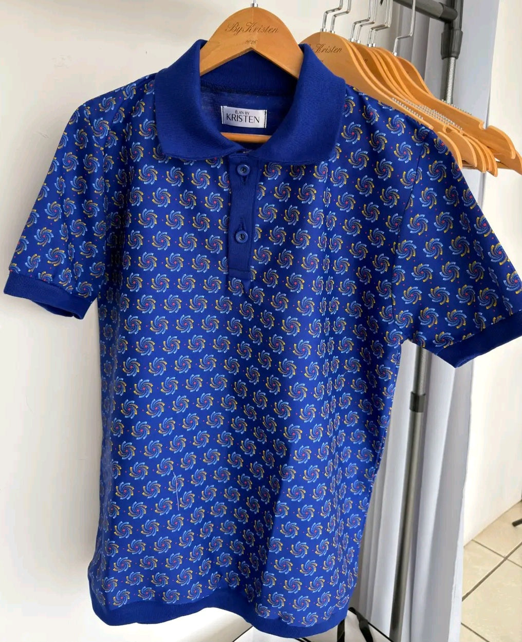 Shweshwe Golf Tshirt in Blue Heritage Swirl print on a hanger