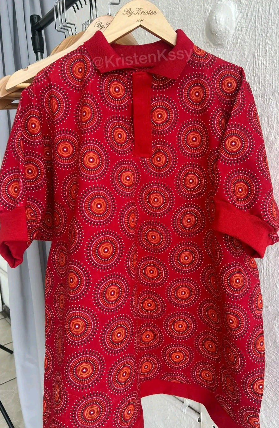Shweshwe Golf Tshirt in Red Sunburst Circle print on a hanger