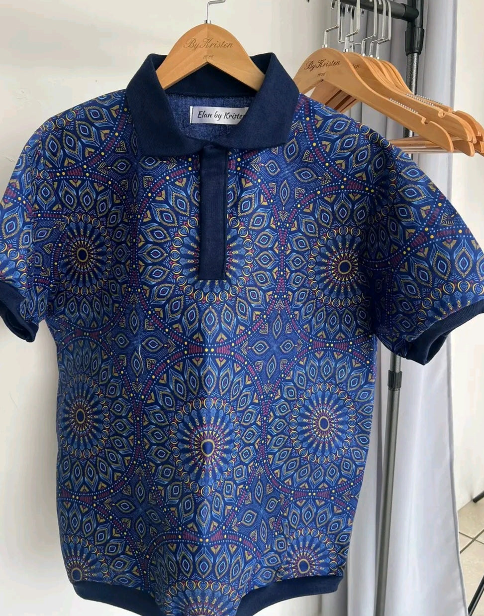 Shweshwe Golf Tshirt in Navy Mandala Bloom print on a hanger